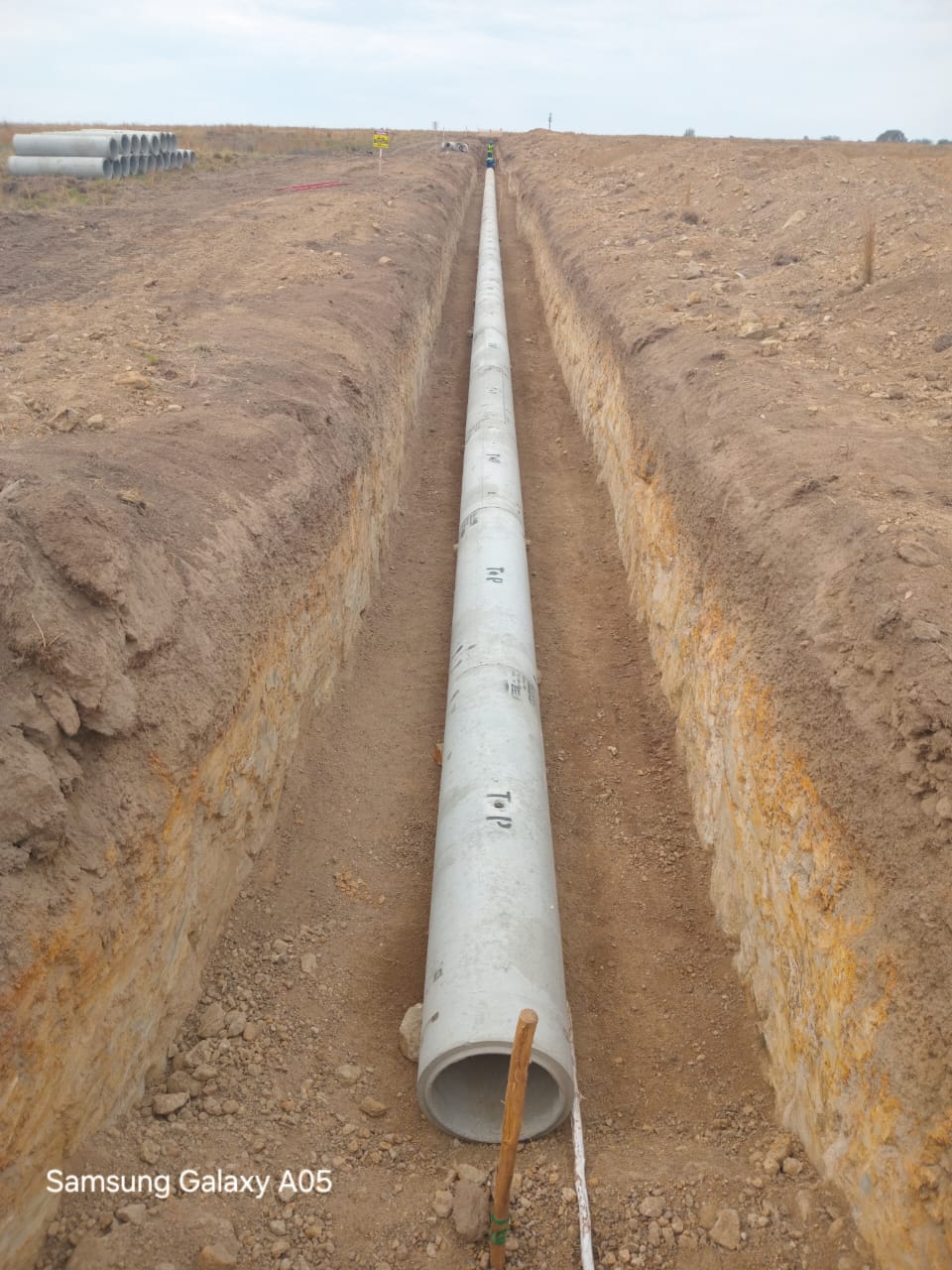 Long section of steel pipe installed in a deep trench.