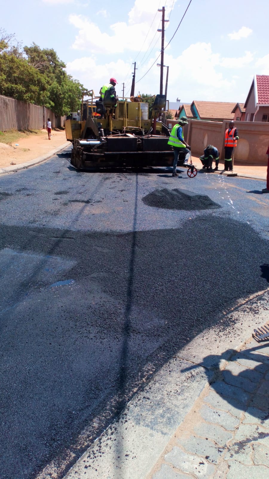 Team completing asphalt road surfacing.